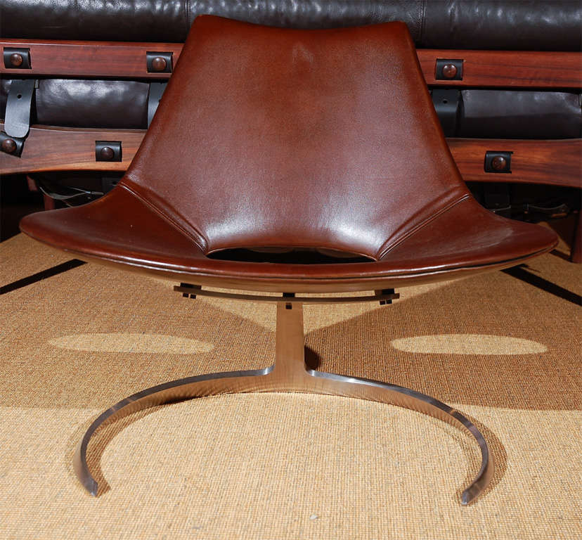 Pair of brown leather easy chairs with stainless steel frames.