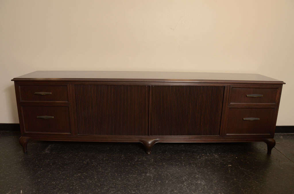 This exceptional crafted credenza / sideboard designed by Maurice Bailey  for Monteverdi Young has wonderful lines with central sliding doors which are flanked by two drawers on either end and has been newly restored to its original beauty.