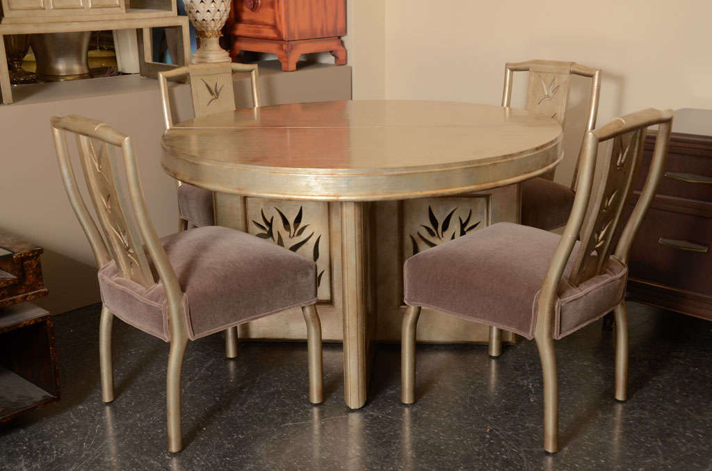 Beautiful dining table and four chairs by JAMES MONT. The table and chairs have beautiful carved bamboo detailing to them and have been finished in a glazed silver leaf finish. The chairs are upholstered in a dark taupe mohair fabric.