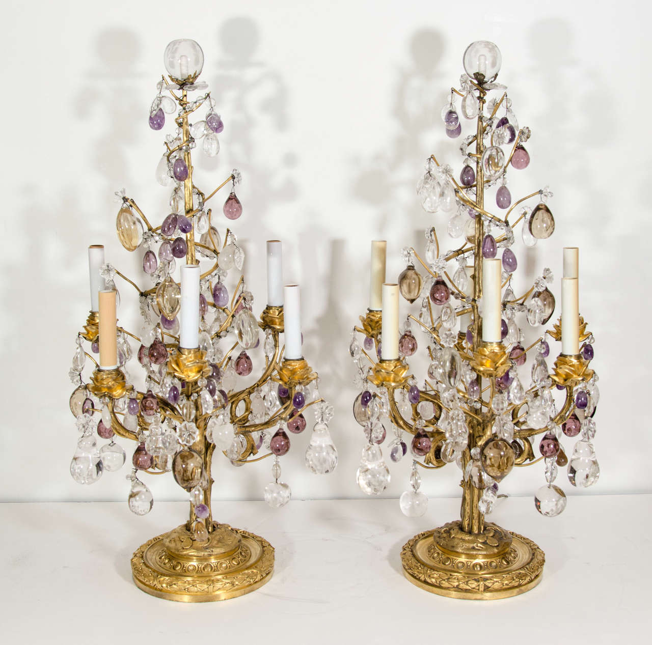 Paire d'exquises et rares lampes de table de style Louis XVI en bronze doré, cristal de roche taillé, cristal de roche améthyste et verre ambré, ornées de bras floraux en bronze doré et de fruits en cristal de roche et de prismes de différentes