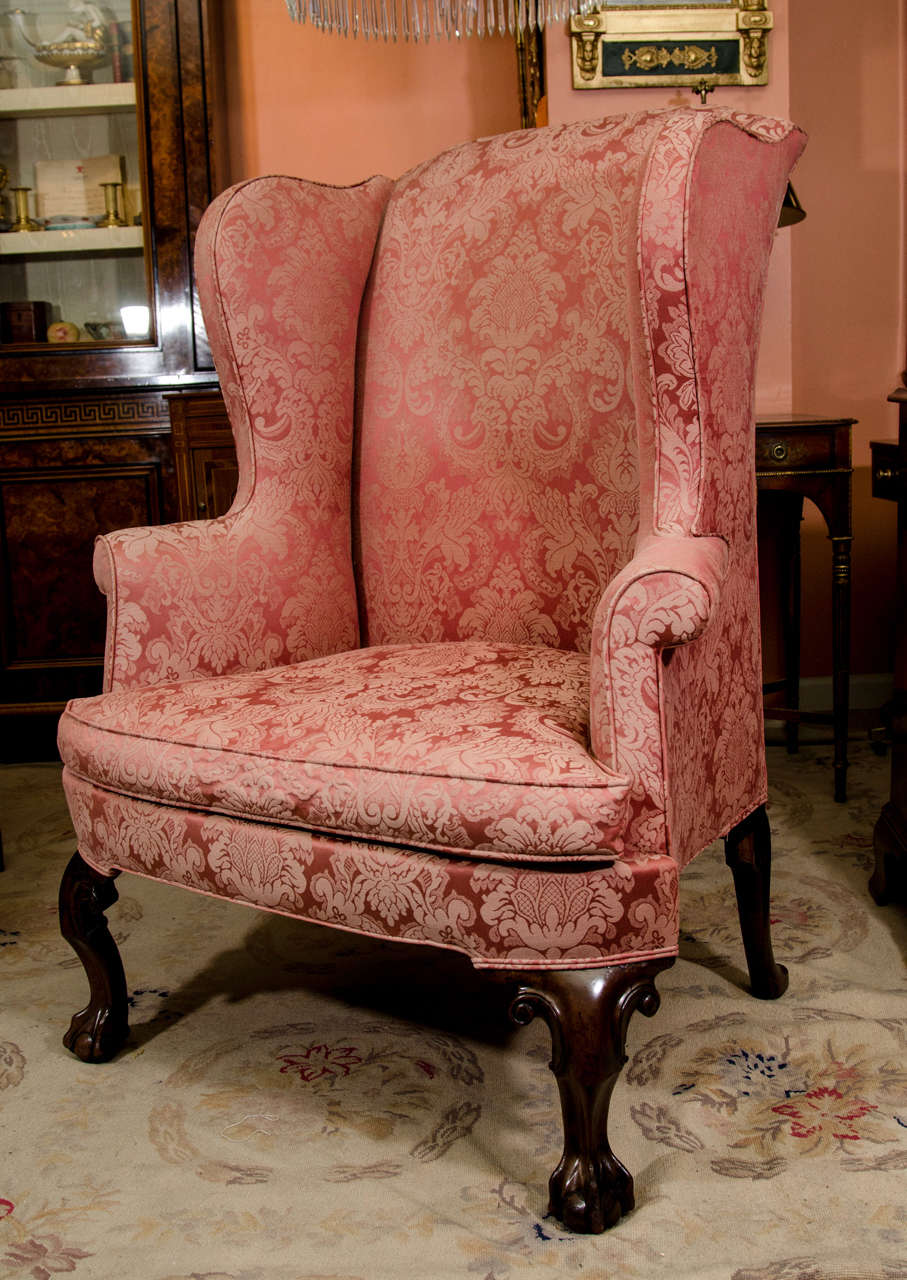 A Fine George II scroll arm wing chair with carved ball and claw feet and bow front rail.