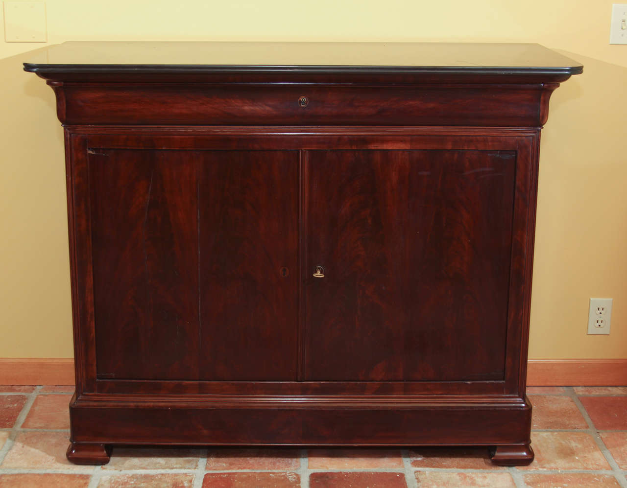 Louis Philippe Mahogany Buffet

This is a handsome Louis Philippe period buffet with a black stone top.

Under the stone top there is a single, original dove-tailed drawer in the shape of a Roman ogee.

The body of the chest features two doors