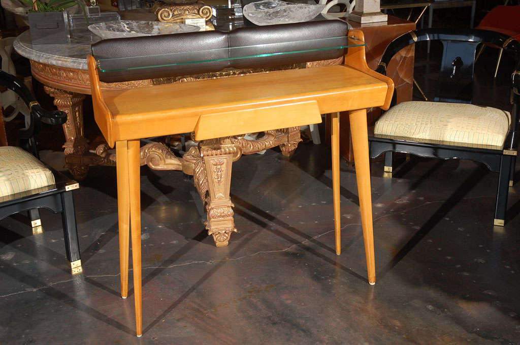 A striking pair of midcentury Italian vanities/consoles by Carlo di Carli. There is one center drawer and a glass shelf on each piece. Leg clearance is 26 inches. Price is for the pair. Please see separate listing for a pair of matching benches.