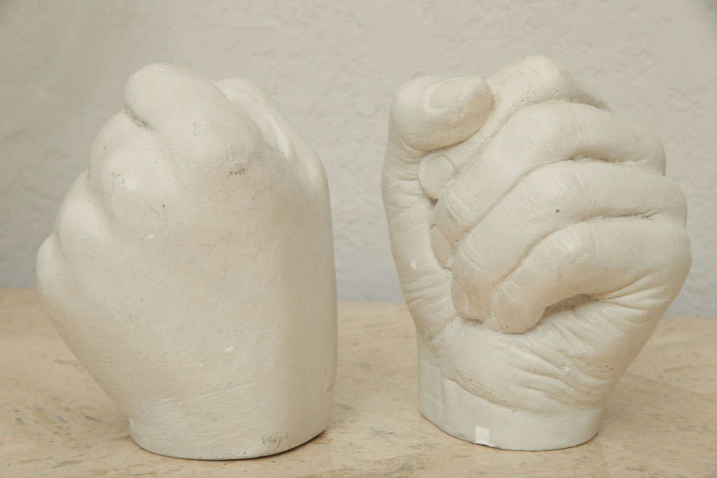 Each fist grasps a taper in this whimsical pair of cast plaster candlesticks by Richard Etts. Signed.