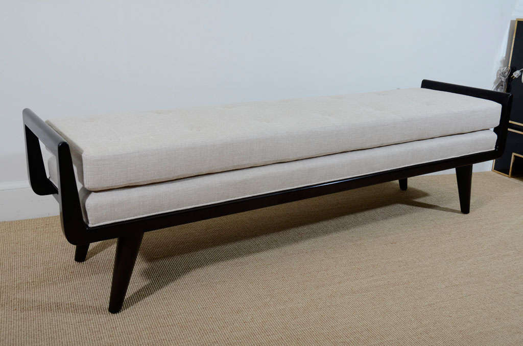 The long bench with shaped rounded handles and upholstered seat, raised on short tapering legs. This is custom-made to the size and finish you require, with your own fabric.
