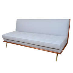 A T.H. Robsjohn-Gibbings Upholstered Sofa on Brass Legs.