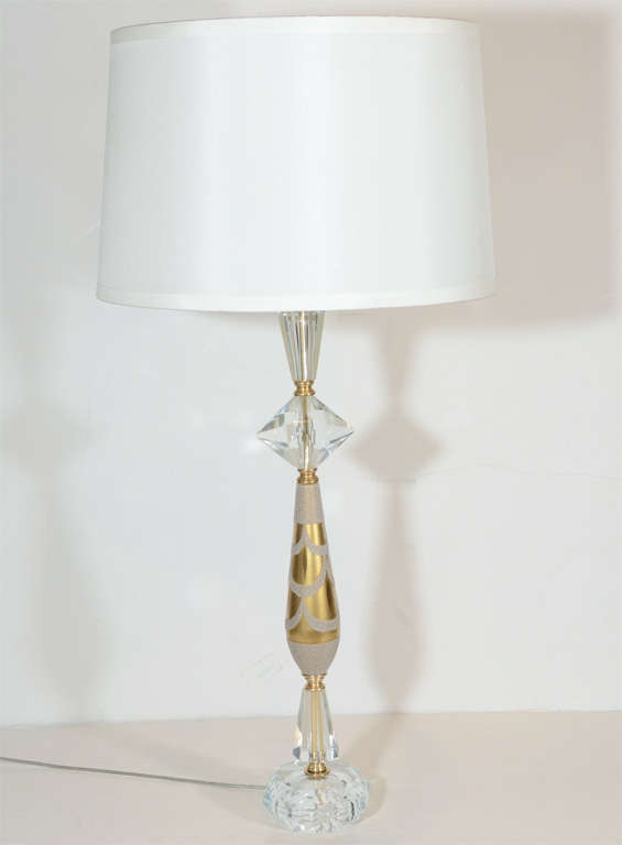 Elegant Hollywood era table lamp comprised of 
faceted cut crystal elements with diamond and
trapezoid forms.  Lamp also has octagon faceted
cut crystal base and gold mercury glass fitting
with sand blasted details.  The lamp has brass
fittings