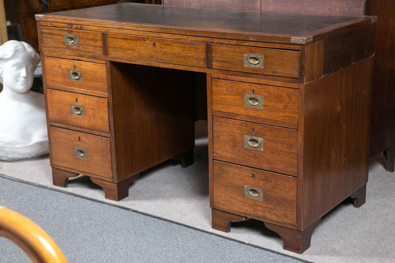 Antique English leather top Campaign desk with recessed brass drawer-pulls and brass-mounted corners. The desk is stamped Salisbury 1891 on one pedestal. Desk is three parts.
