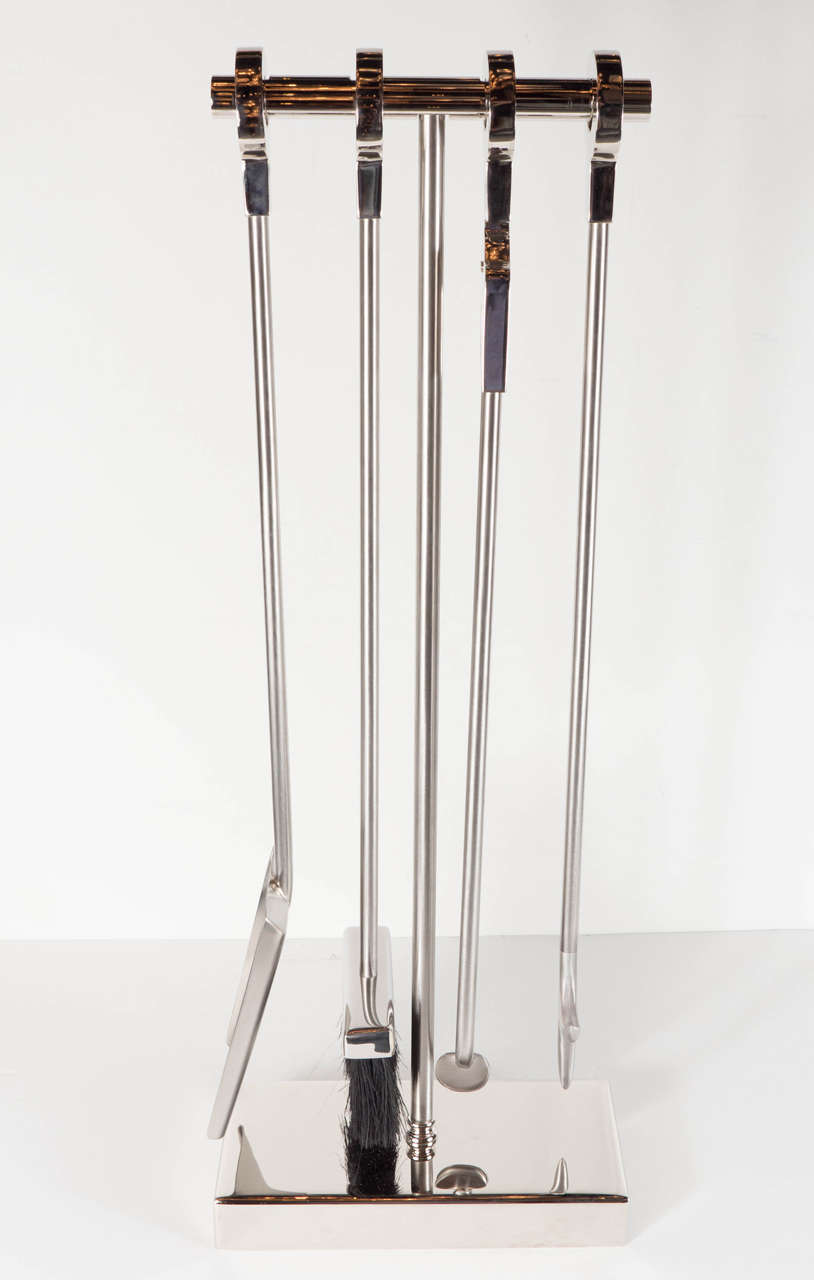 This exceptional custom four-piece fire tool set consists of a stoker, shovel, brush and log holder with polished nickel handles and brushed nickel rods, neatly suspended from a polished nickel 