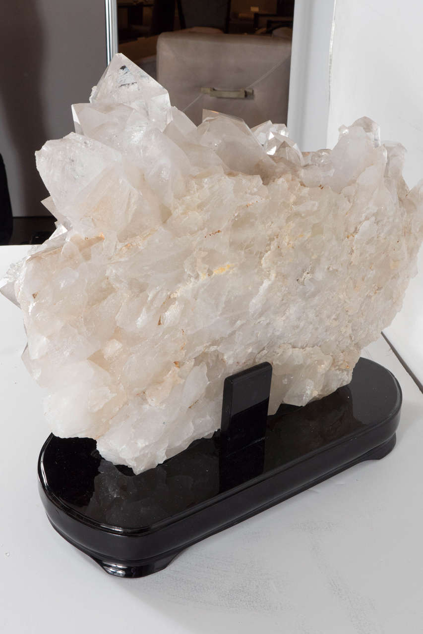 This stunning rock crystal mineral specimen is a gorgeous natural formed quartz. As time progressed this beautiful hue of pearl has formed angular crystal shapes, and is situated on a black ebonized walnut base.