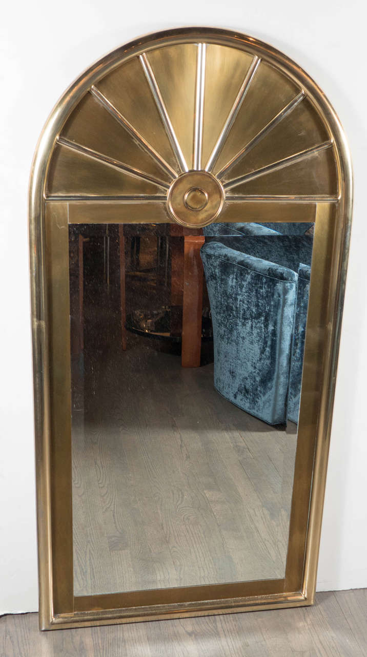 This exceptional Mid-Century Modernist mirror consist of an arch form design with a fan detail filling emanating from a circular focal point in the arched portion of the mirror. The mirror is hand beveled and is bordered within the frame with a