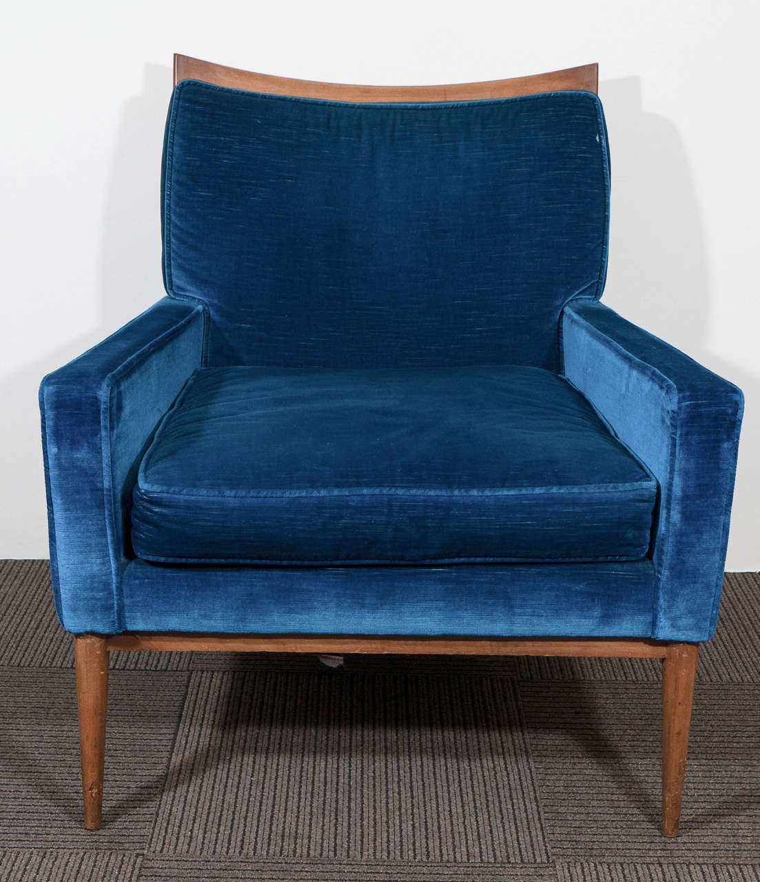 A pair of vintage modernistic armchairs, produced circa 1950s by designer Paul McCobb for Directional Furniture, upholstered in blue velvet against wood frame, on tapering legs. Good vintage condition, with some age appropriate wear, including minor