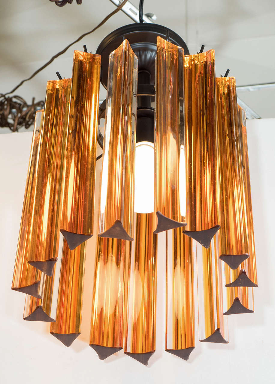 A vintage Italian chandelier, produced circa 1970s, with suspended amber colored Murano glass triedre prisms. Wiring and socket to US standard, requires one Edison base bulb. Good vintage condition, with age appropriate wear, original glass prisms,