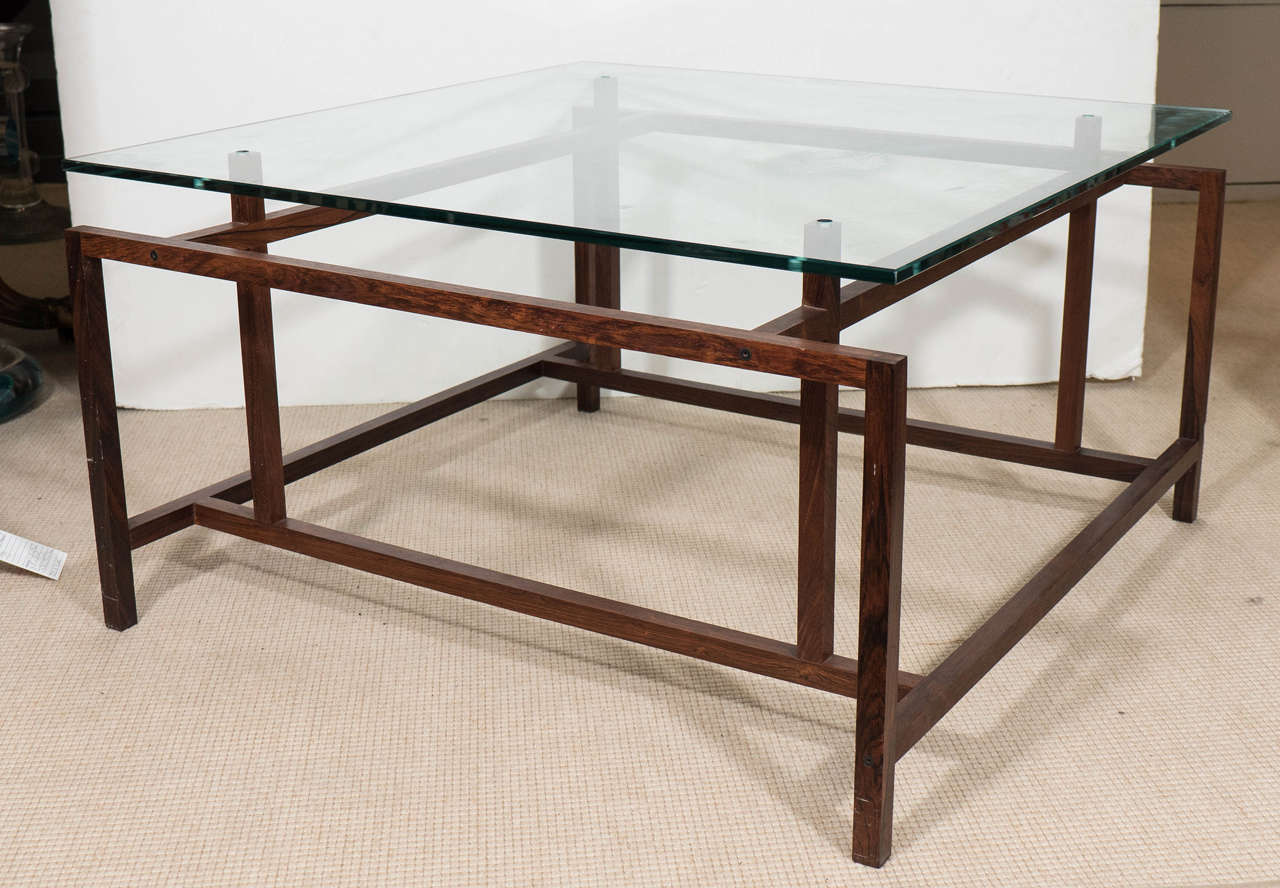A Danish modernistic coffee table by designer Henning Norgaard for Komfort, produced, circa 1960s, with rosewood frame and glass top. Very good vintage condition, consistent with age and use, with new glass top.