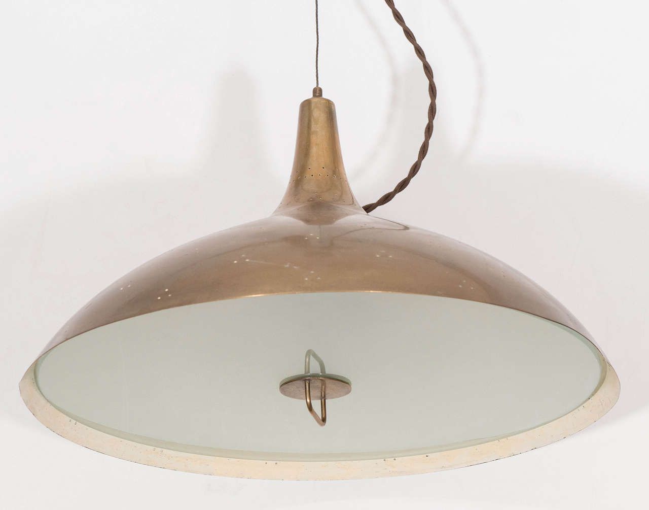 A counter balance pendant lamp, produced in Finland, circa 1950s by designer Paavo Tynell, including a unique pulley, to adjust the height of the light fixture from the ceiling, which suspends a brass bell-form shade, decorated with perforated