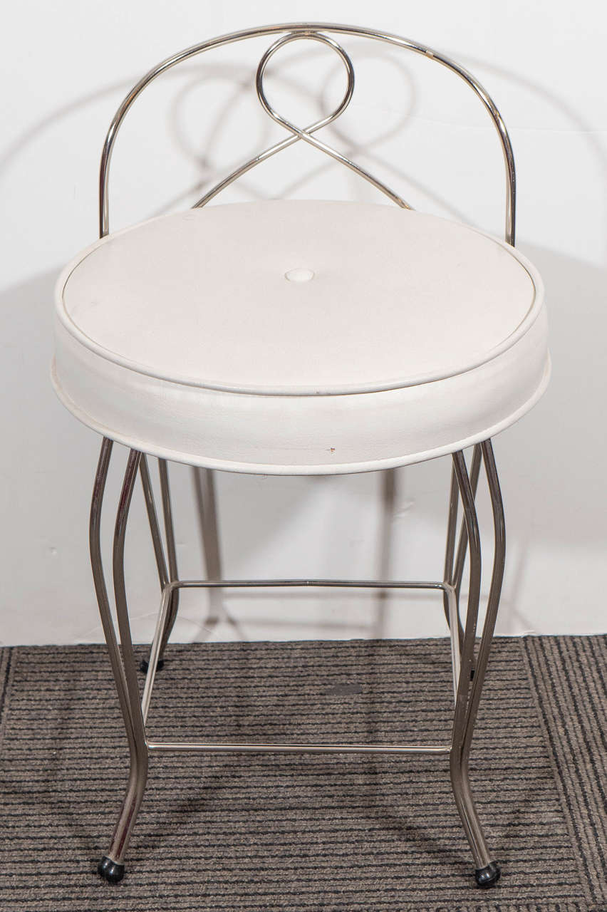 A pair of vintage vanity stools, produced circa 1950-1960 by George Koch Sons, Inc., both with white vinyl, tufted seats, against curved chrome frames. Very good vintage condition, with minor pitting to chrome, consistent with age and use.