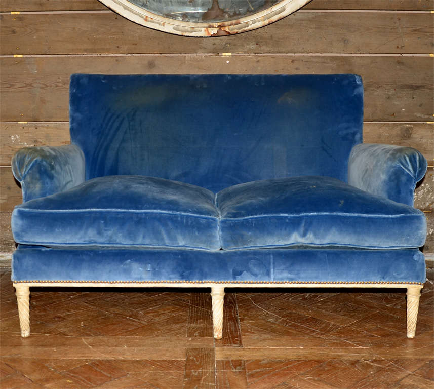 1940s two-seater canapé by Carlhian,  with twisted motif on legs, in the original off-white patina. Blue velvet is worn.
