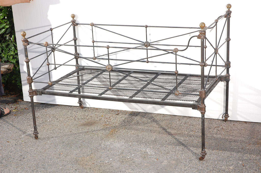 19th century cast and wrought iron folding baby bed. Connecting parts are cast iron. Dark painted finish with bronze colored fittings. Small repair to the mesh bottom. The sides fold down for getting in and out. This would make a great dog bed for a