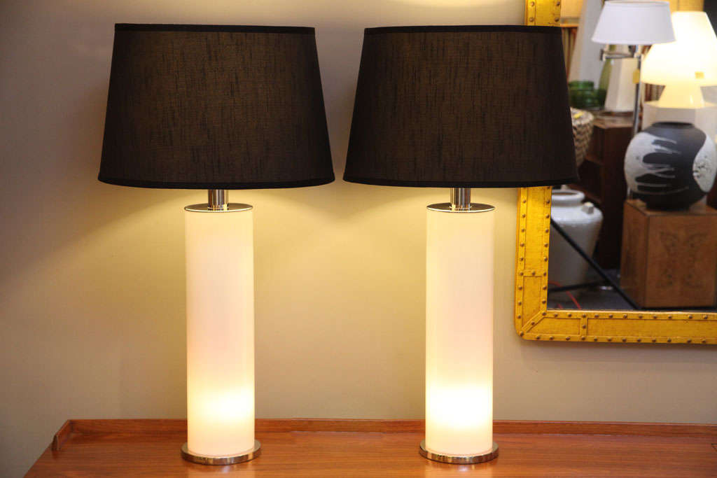 Sleek and exciting pair of white columnar table lamps with nickel mounts and base. Featuring three way lighting choices the white acrylic column can be lit as well as the normal shaded area, either together or individually. The lit column makes a