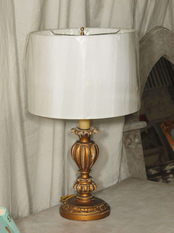 Originally a candleholder, this single carved giltwood lamp is gorgeous in its fine details and original patina.  Converted into a lamp with a beeswax candle sleeve to keep authenticity and look. Newly wired for U.S. standards.