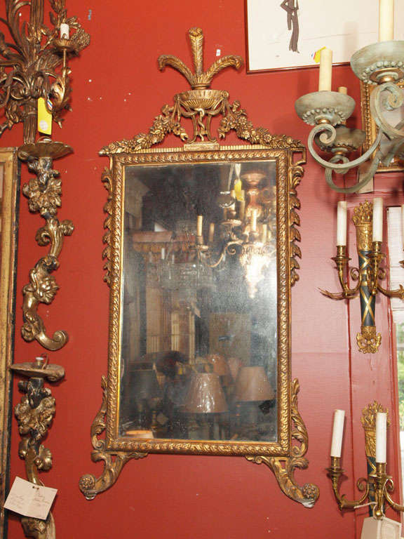 A  Continental mirror in a gold painted carved frame with the 
