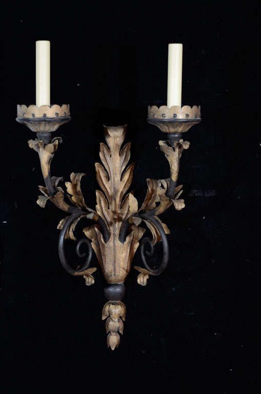 Parcelgilt and polychromed iron two light sconces with leaf motif by E.F. Caldwell.
