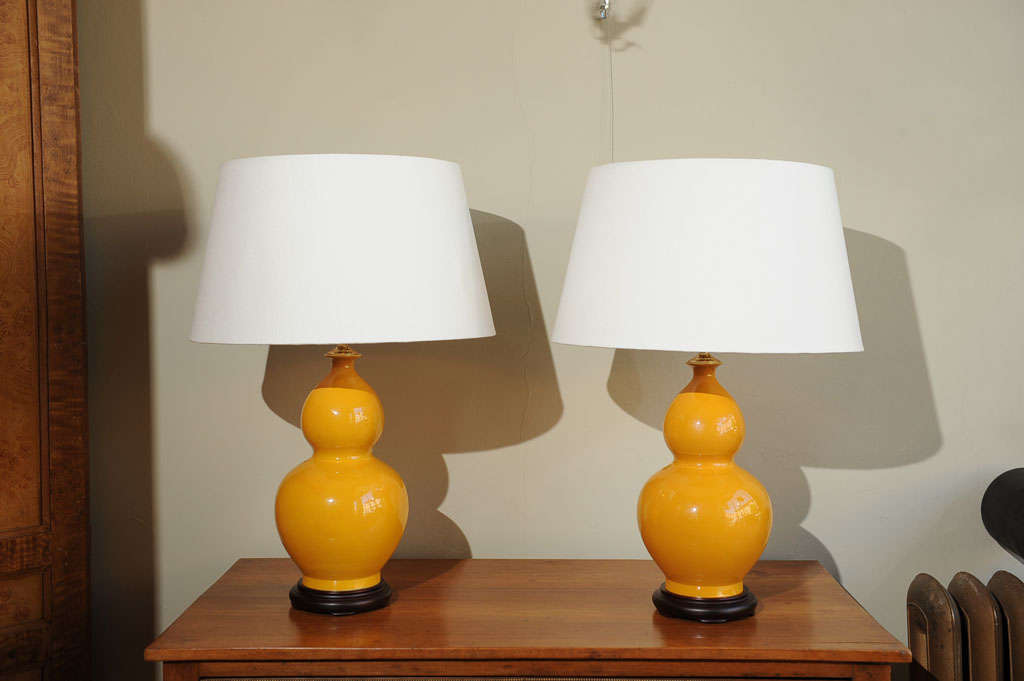 A fine pair of Chinese ceramic lamps on black wood bases. Shades not included.