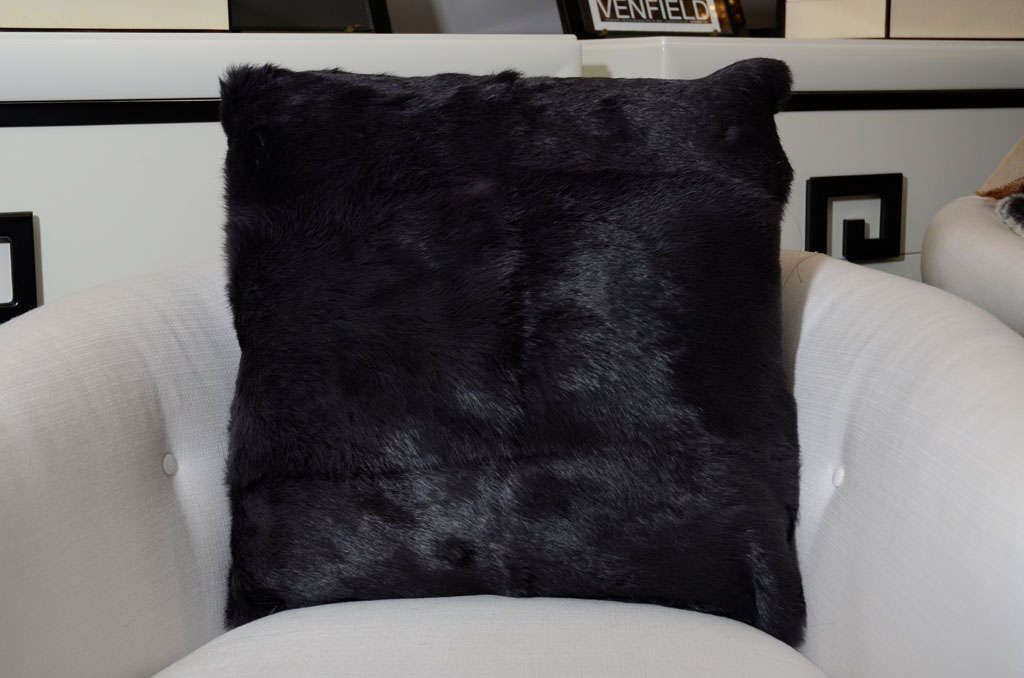 Pair of black fox fur pillows.