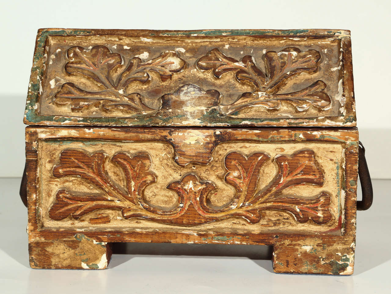 Heavily distressed carved wooden box with iron handles.
