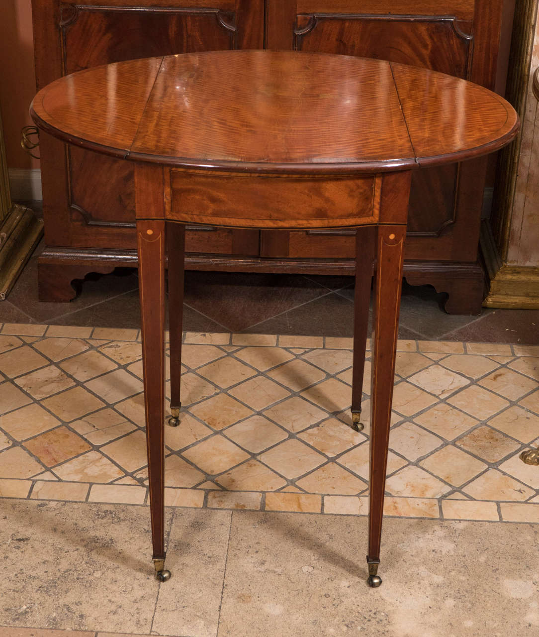 A fine George III (Hepplewhite) diminutive satinwood and rosewood crossbanded oval top pembroke table with slide.