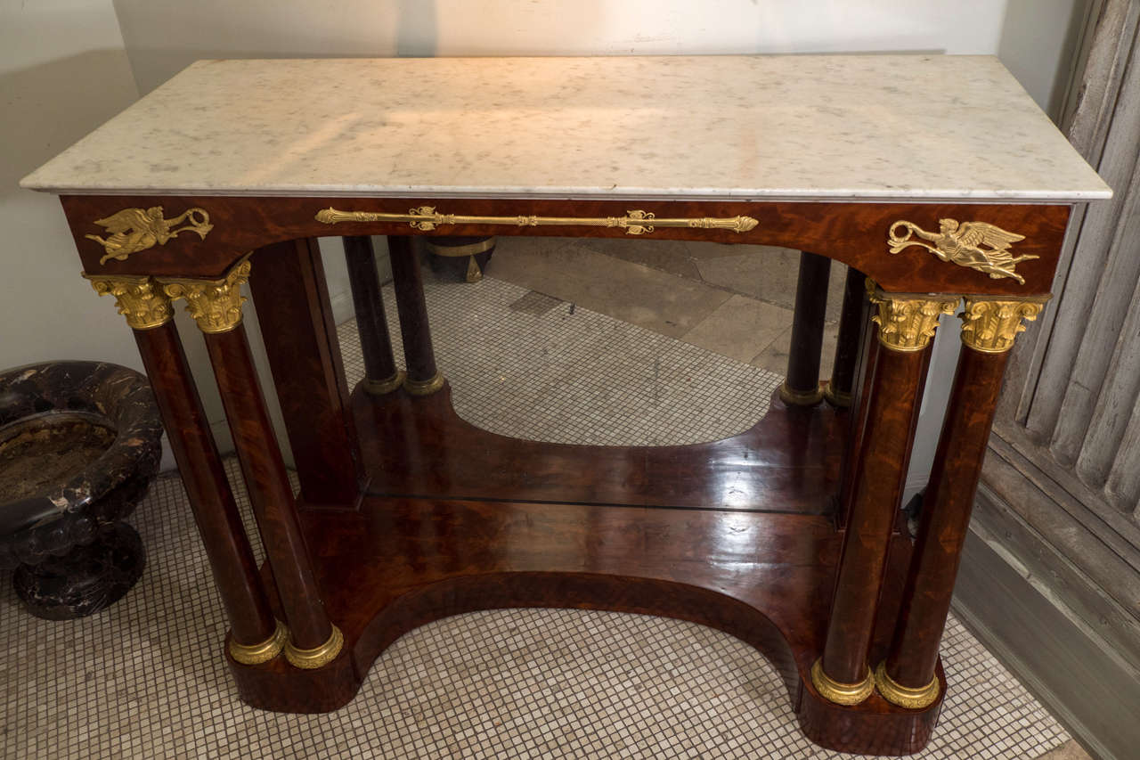 A fine French Empire marble top bronze mounted pier table with bronze capital ionic column supports and mirror.