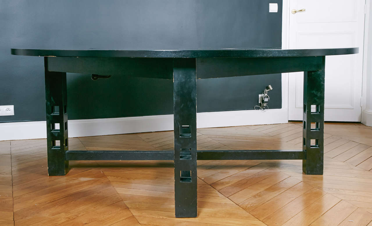 A round stained wood  dining table, Produced by Cassina, after a 1904, Mackintosh design, the top has a revolving central part that can be adjusted approximately 3  cm  (1.2