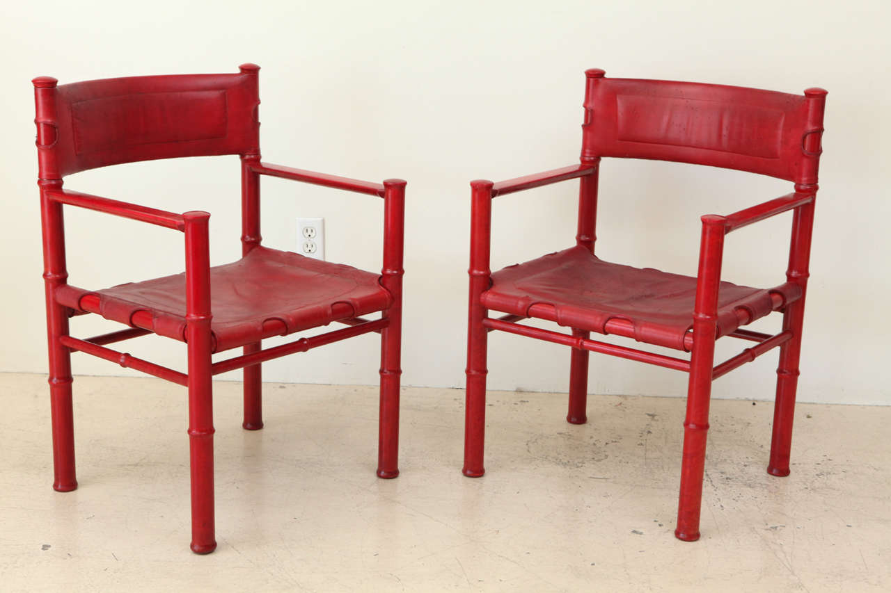 Set of Six aniline red dye stained wood chairs with Leather seats and backs by Asko. Entire set of 6 available for $2,650 or $950 for a pair.