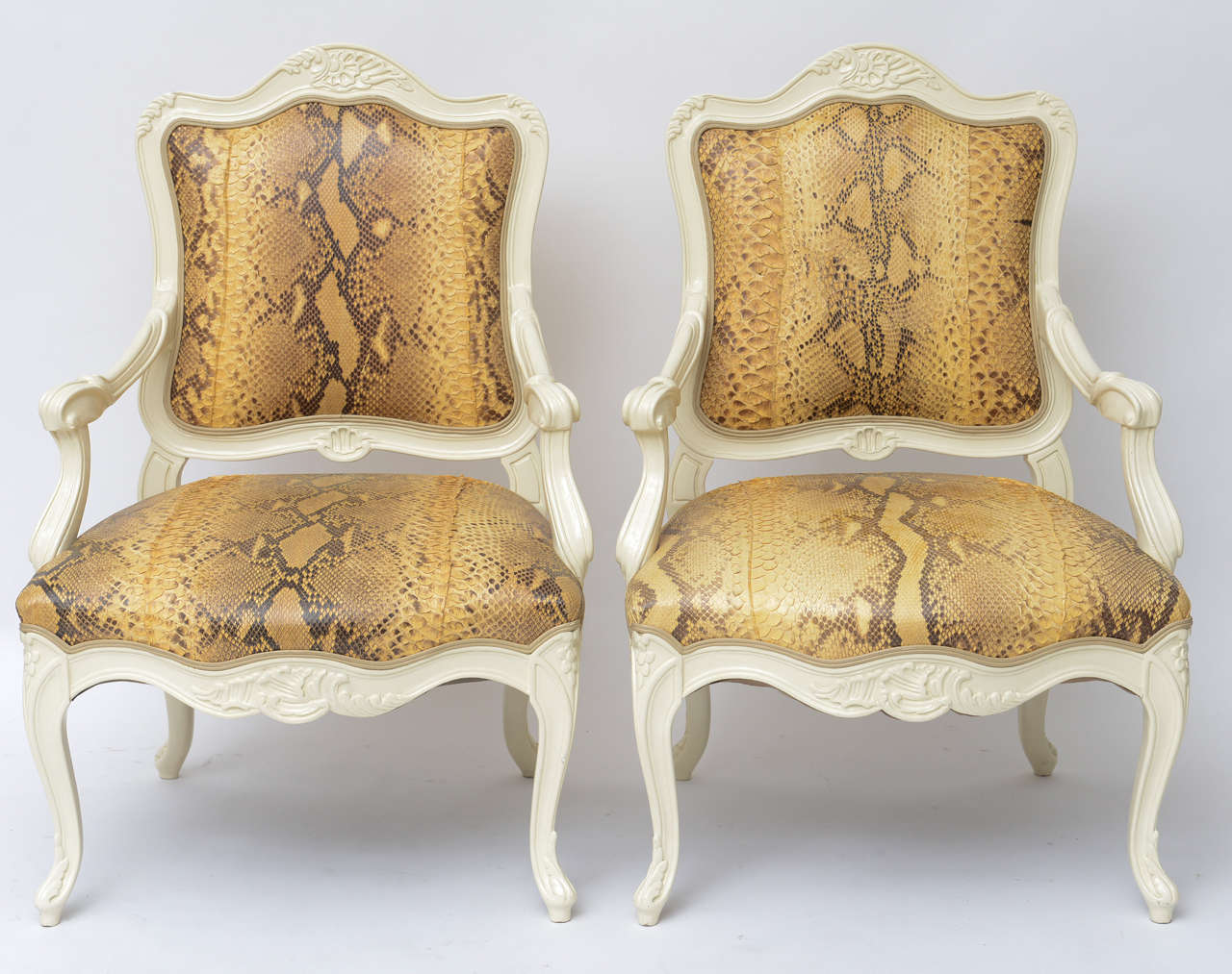 Fabulous pair of cream lacquered Louis XV-style armchairs (likely circa 1970) are taken to another level with gorgeous, glamorous, genuine python upholstery, as found. Delicate double welting in beige leather. Price listed is 