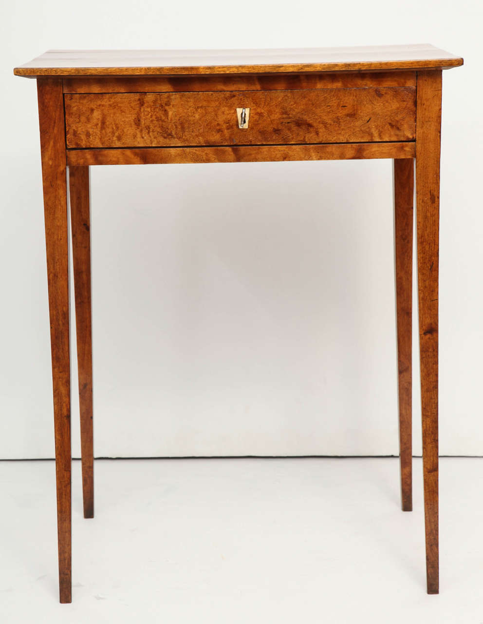 A Swedish Late Gustavian alrot side table, Circa 1810-1820, with a rectangular top above a single frieze drawer raised on square tapered legs.