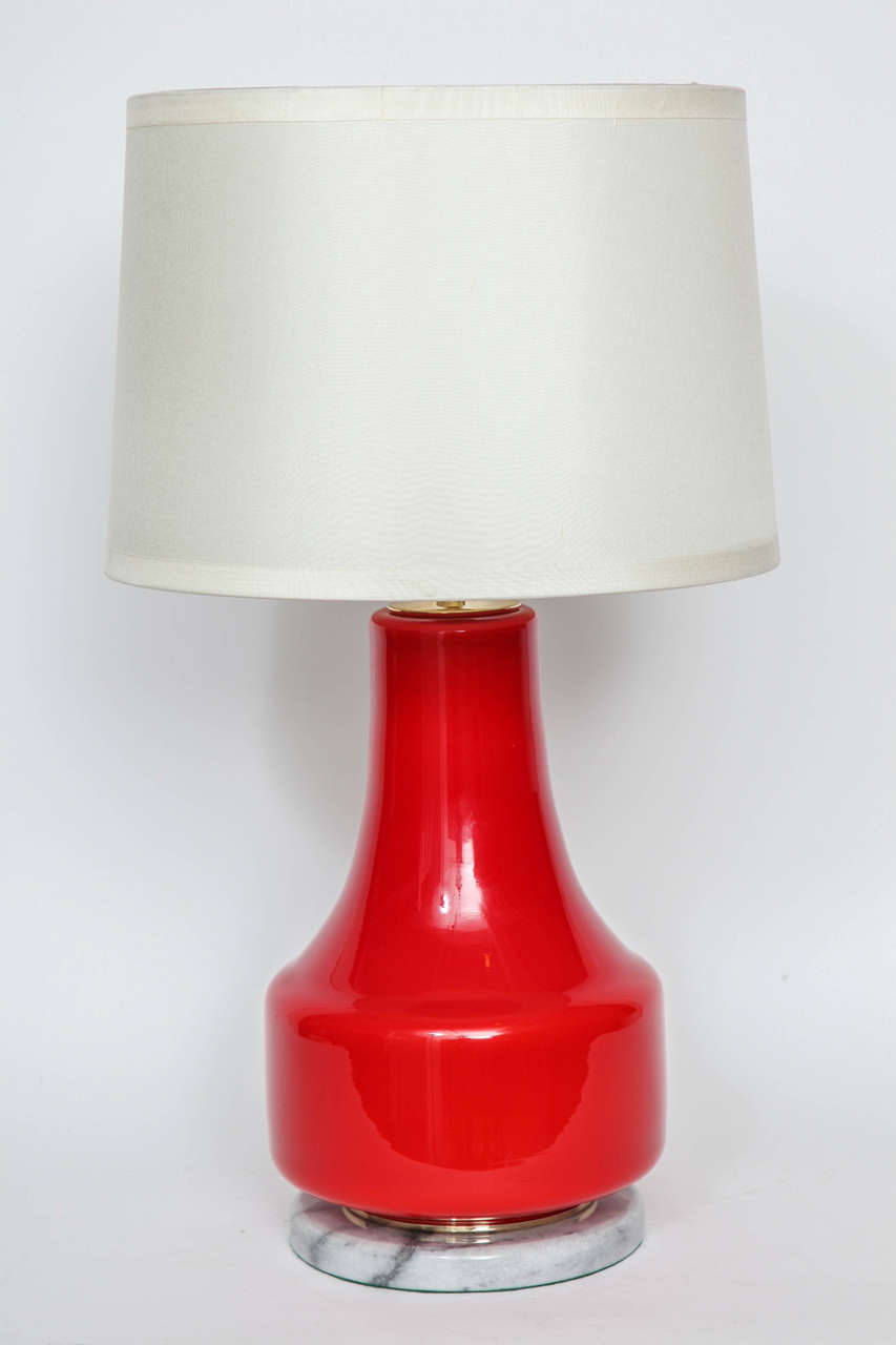 Italian Mid Century  poppy red glass lamps on a light grey marble base with brass detail and sockets. Each lamp has 1 socket, 100W max.