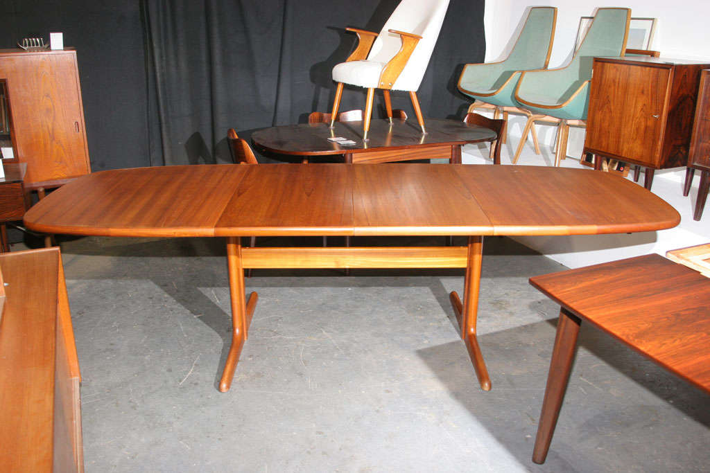 Nice unusually shaped Danish Modern Teak Dining Table.  Features a centered base which allows for extra seating and 2 additional leaves each measuring 19.75