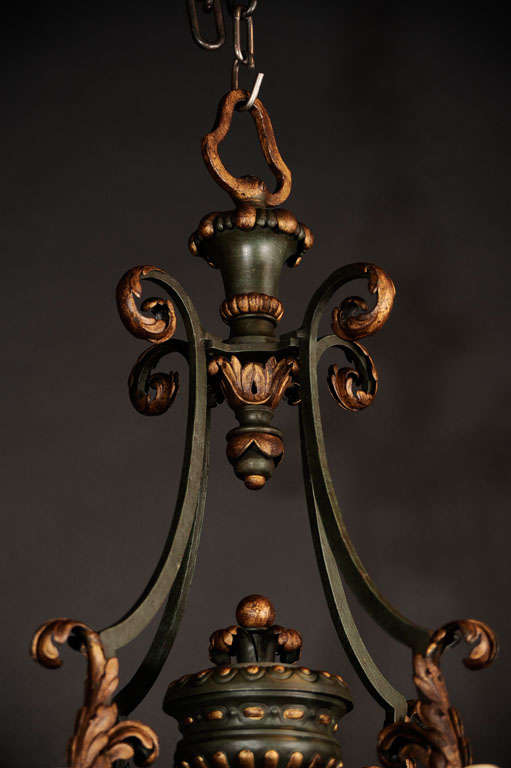 Louis XV style gilt and polychromed iron eight light chandelier.  The bobeches and chandelier cage supports are decorated with gilded ancanthus leaves.  The center section supports a gadrooned urn.