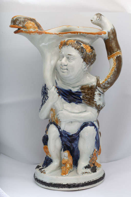 A rare English pearlware Bacchus toby jug decorated in underglaze Pratt colors with mdeallions of George III and Charlotte on the barrel and figure of the widow on the front