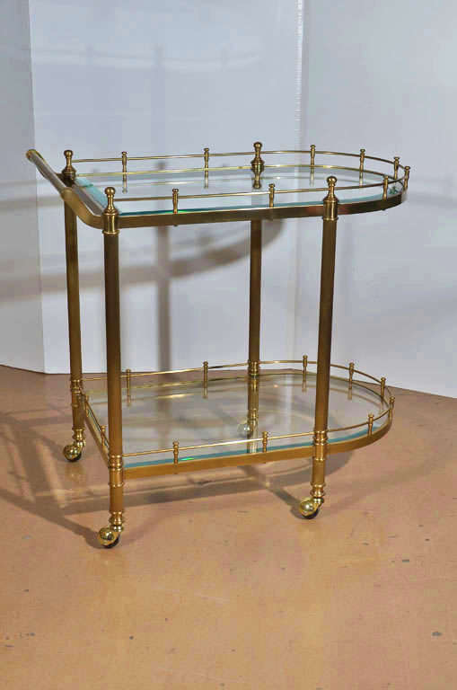 A well crafted solid brass Italian 2 tier glass shelves bar or tea cart with gallery rail and caster wheels.