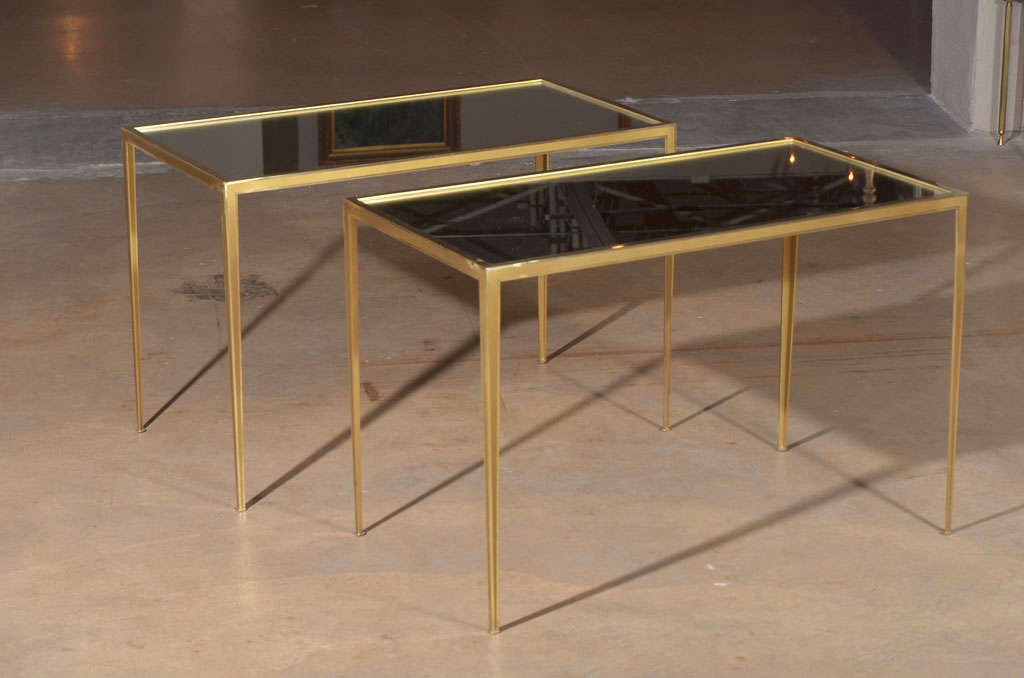 Pair of delicate crafted brass frame side tables with inset mirrored tops. Brass frame has matte detailing with traces of slight use.