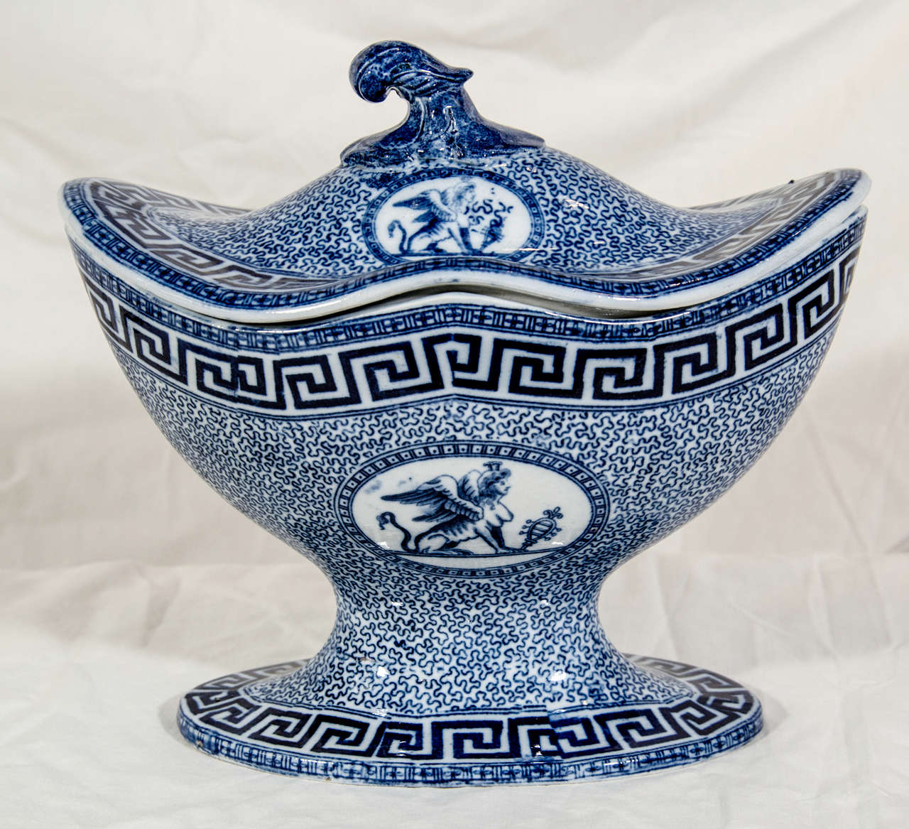 A Blue and White Staffordshire small oval shaped tureen with an over all neoclassical design with vermiculi, a Greek key border, and a sphinx in medallions.