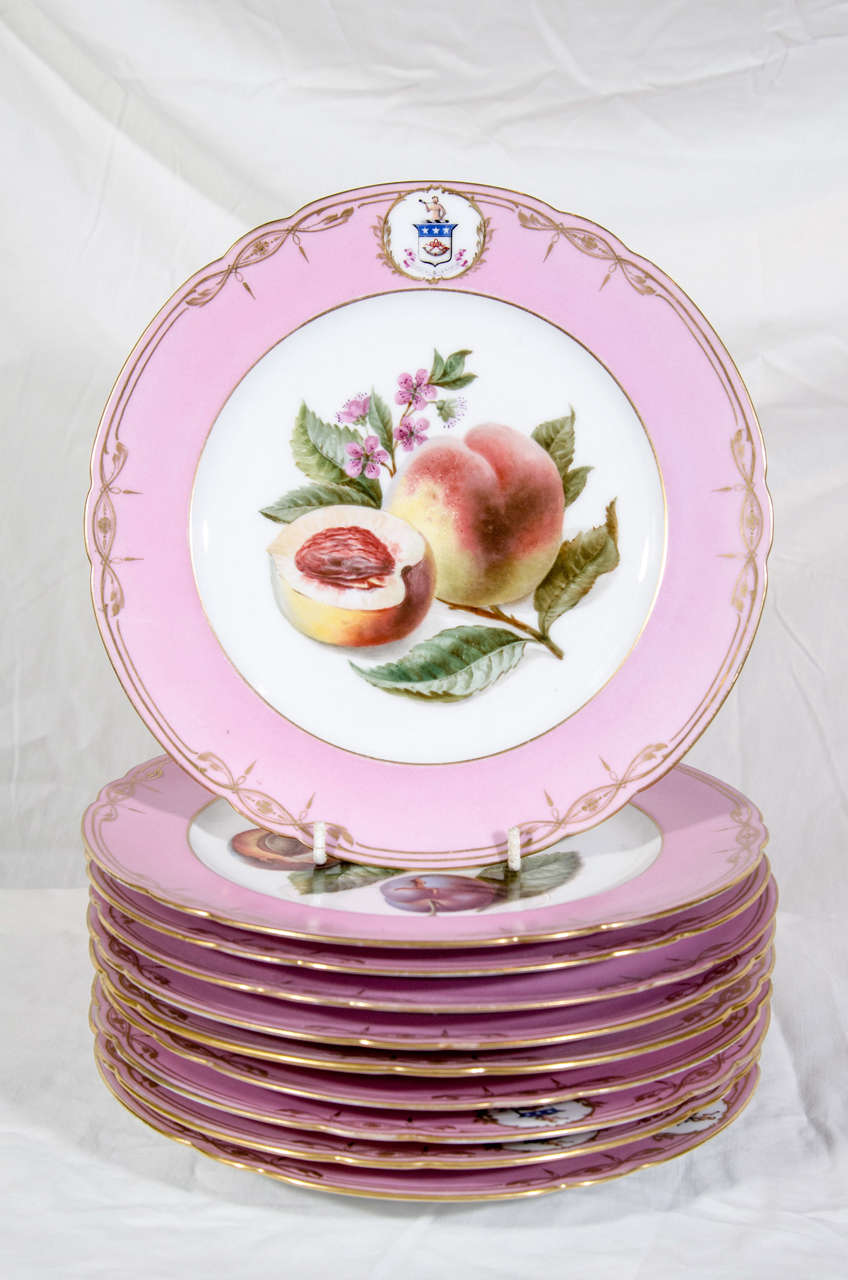 A group of a dozen Paris Porcelain dishes each with an individual beatifully painted fruit, pink border, and armorial. 10 plates showing fruits 2 plates showing flowers. 
 Made by Feuillet, for the American market, and bearing the The