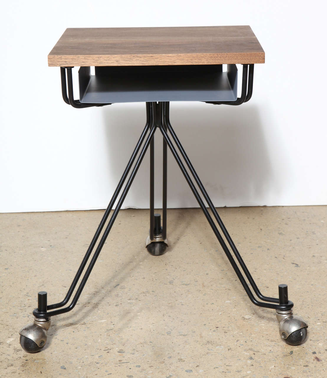 Mid 20th Century pair of Eliot Noyes designed IBM Rolling Typewriter Stands. Featuring Black enameled Iron wire tripod legs, 3 round casters, lower Gray enameled metal shelf with custom Solid Walnut Surface. Great rolling multi use Table for small,
