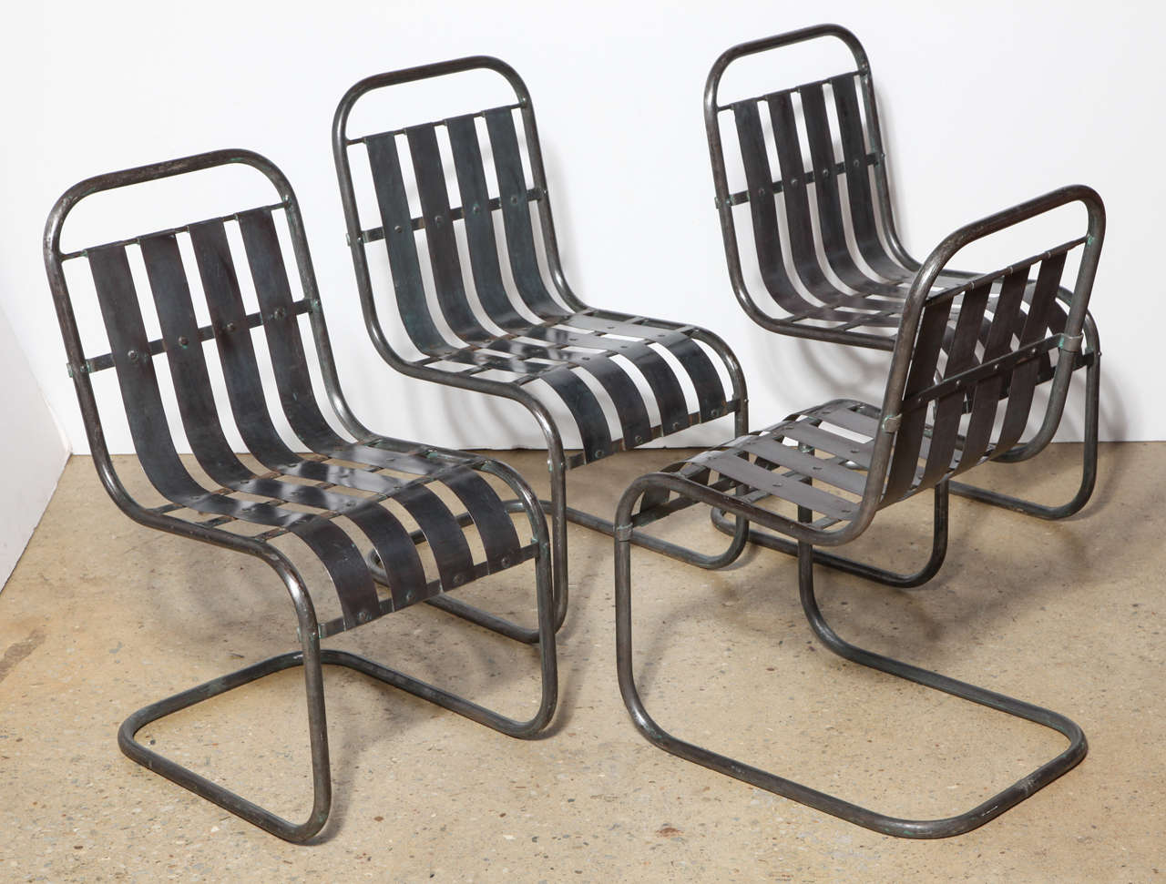 Modern Industrial Set of 4 Steel Spring Rocking Side Chairs. Featuring heavily riveted tubular bent Steel. Smooth rocking movement.  Comfortable. Porch. Veranda. Pool House. For use in covered area, with or without cushions. Paint removed. Standard
