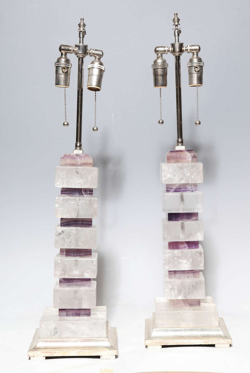 A pair of very fine rock crystal and amethyst quartz crystal geometric patterned table lamps on gilt wood bases. These striking geometric lamps are hand cut and hand polished rock crystal and amethyst quartz of the finest quality. When the lamps are