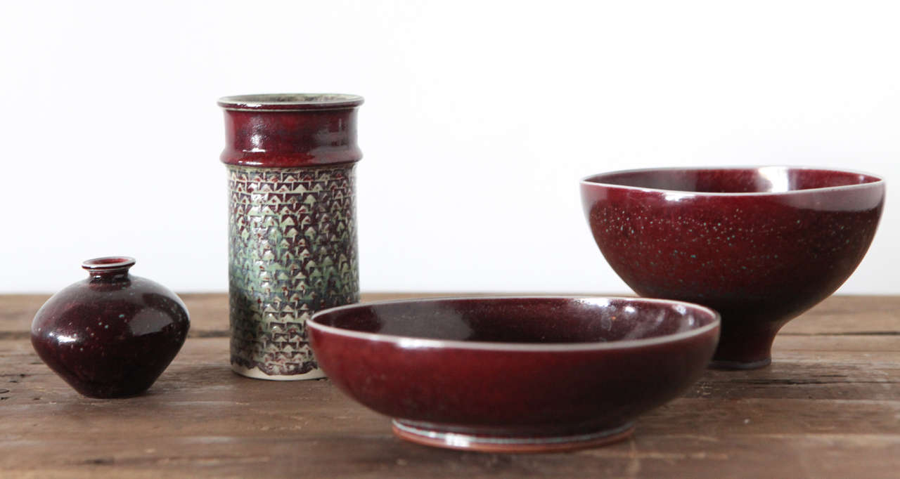 A collection of plum colored ceramics from Sweden & Denmark.
All pieces correctly marked with artist signature and production stamp.
From left to right

a) Berndt Friberg low burgundy speckled vase height 3 diameter 3.25 900. net.

b) Stig