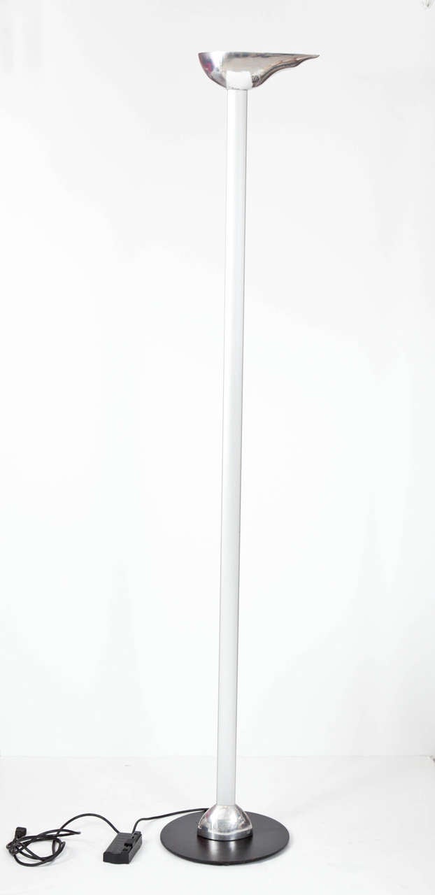 Cast and polished aluminum flame shaped shade atop a matte'finished aluminum column, supported by a black enamel steel base. A great 1990s design by Ron Rezek. Floor rheostat adjusts brightness of 300W halogen tube bulb. Shade 11 deep x 3 1/2