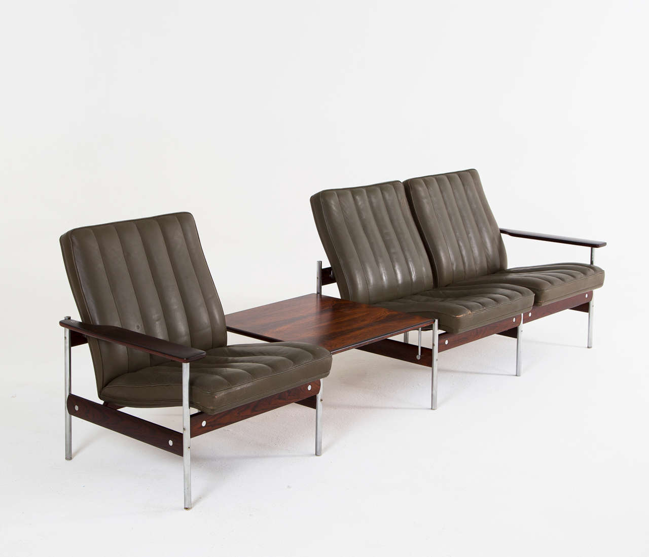 Very sophisticated three-seater sofa by Sven Ivar Dysthe for Dokke Møbler, Norway, 1959. The base of this setee is made out of modular rosewood and stainless steel pieces. A clever design makes that the seat seems to float on its base.

The seats