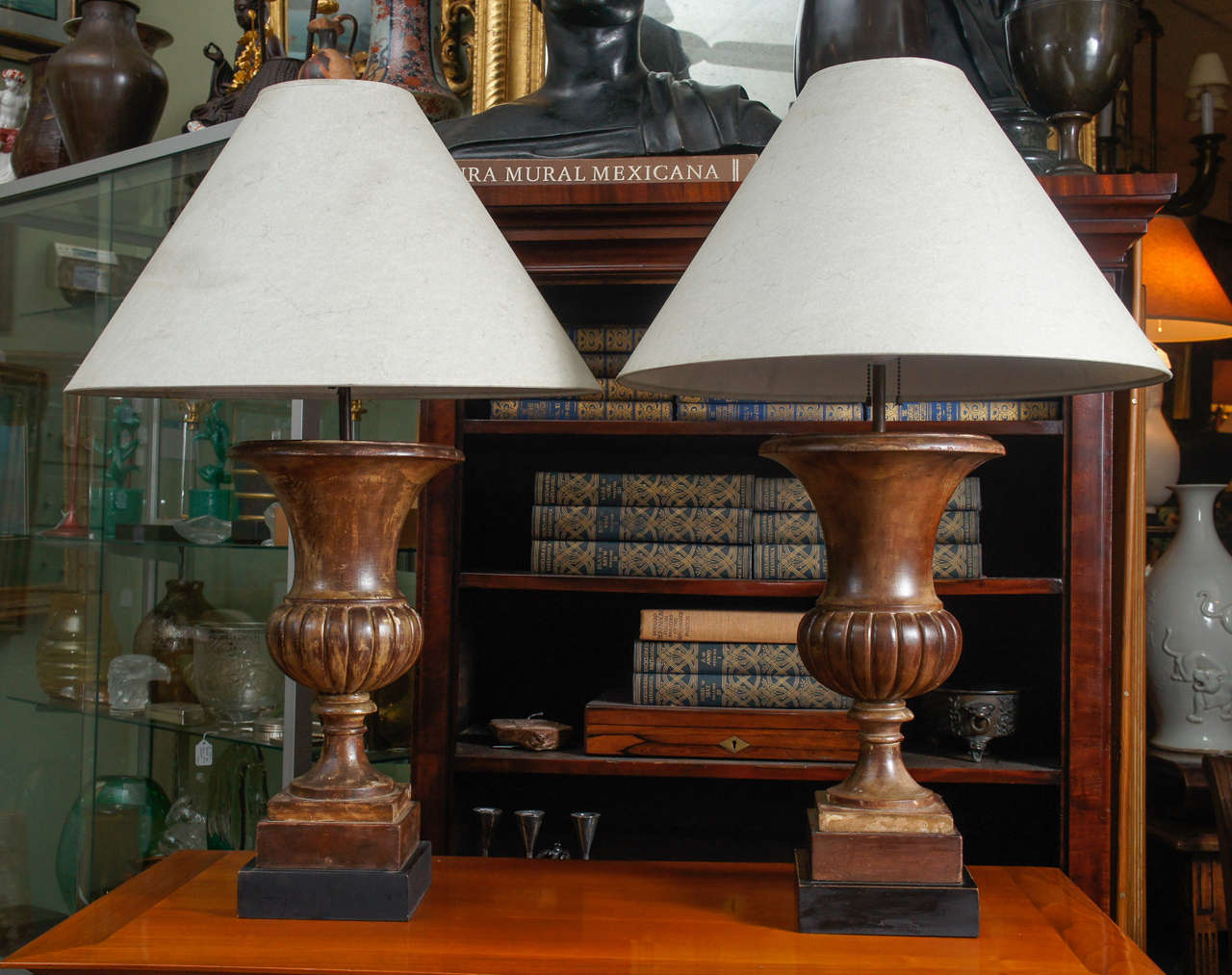 Pair of 1940s classical urn lamps in carved wood.